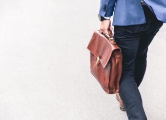 person walking holding brown leather bag