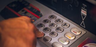 person holding white and red card