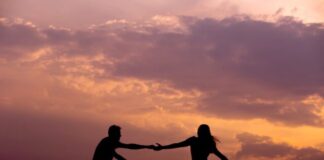 woman on bike reaching for man's hand behind her also on bike