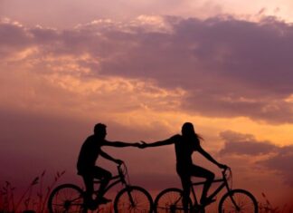 The Effects of a Relationship on Your Physical and Mental Health woman on bike reaching for man's hand behind her also on bike