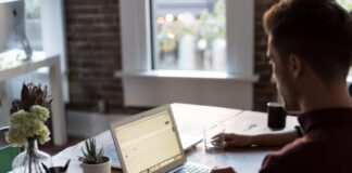 man operating laptop on top of table