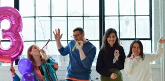 smiling people standing near table