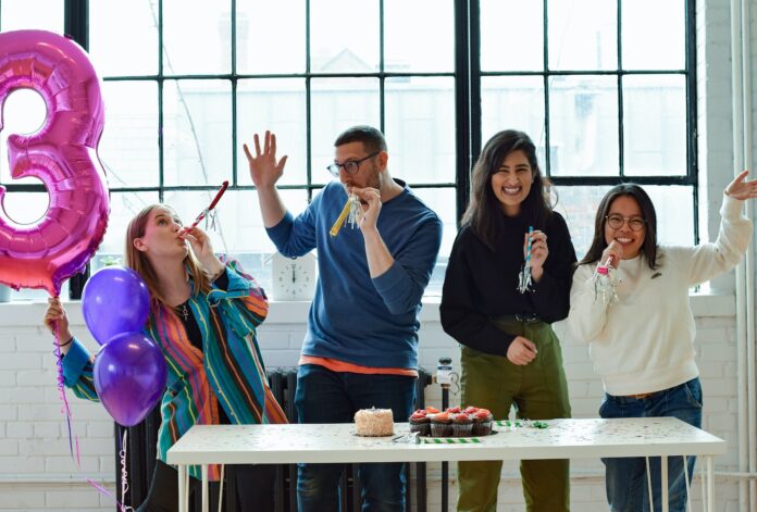 Photo by Jason Goodman smiling people standing near table