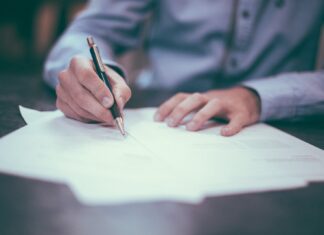 7 Common Auto Insurance Discounts man writing on paper