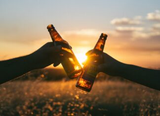 How to cope with someone who is suffering with alcohol addiction photography of person holding glass bottles during sunset
