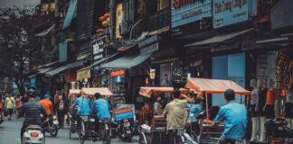man driving white motor scooter on road