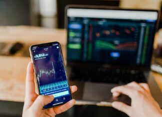 Sonder Group Review – A New Angle on Online Trading person using phone and laptop computer