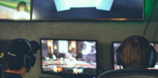 selective focus photography of two persons playing game in front of monitors