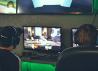 selective focus photography of two persons playing game in front of monitors