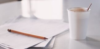 vaso desechable blanco y papeles