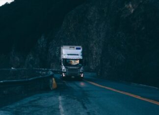 Best Reasons to Get Fleet Management Software for Your Company trailer truck passing on road near rail guard