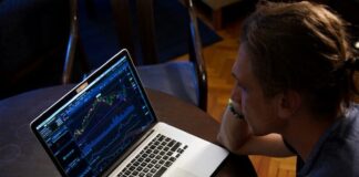 man sitting in front of the MacBook Pro