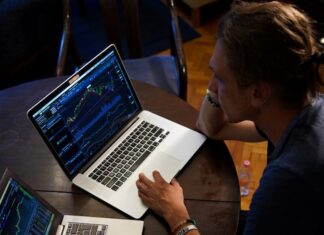 Considerations for Selecting a CFD Trading Strategy in the UAE man sitting in front of the MacBook Pro