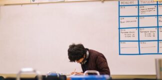 man in brown sweater sitting on chair