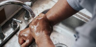 person in grey t-shirt washing hands