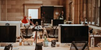 turned off flat screen monitors on top of beige desks