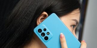 woman in white shirt holding blue rectangular device