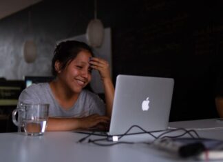 smiling woman using MacBook
