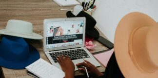 person using macbook air on brown wooden table