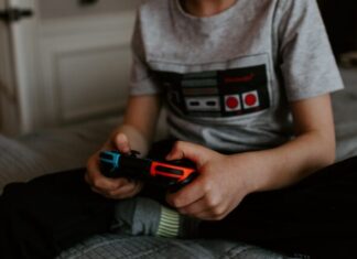How You Can Use NFTs in Video Games kid sitting on gray bed while playing
