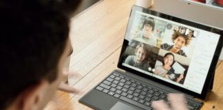 person in blue long sleeve shirt using black Surface