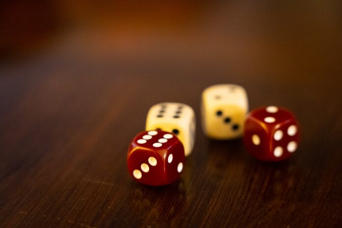 Photo by Nick Fewings seven white and red dices on brown wooden table