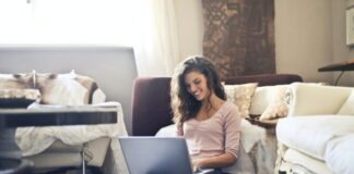 Woman Smiling While Using Laptop