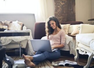 Woman Smiling While Using Laptop