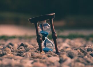 How to Improve Time Management with Time Tracking Software selective focus photo of brown and blue hourglass on stones