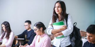 woman carrying white and green textbook