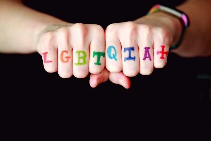 Photo by Alexander Grey person with blue and red manicure