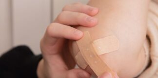 person holding band aid on left hand