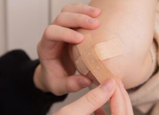 person holding band aid on left hand