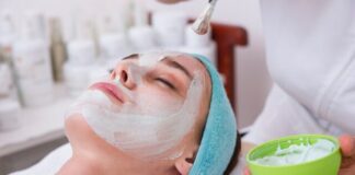 woman lying on blue towel with white cream on face