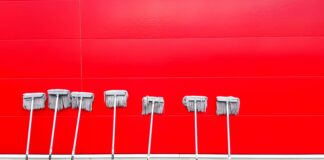 seven white push mops on wall