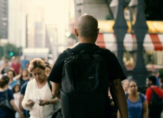 man in black t-shirt carrying black backpack