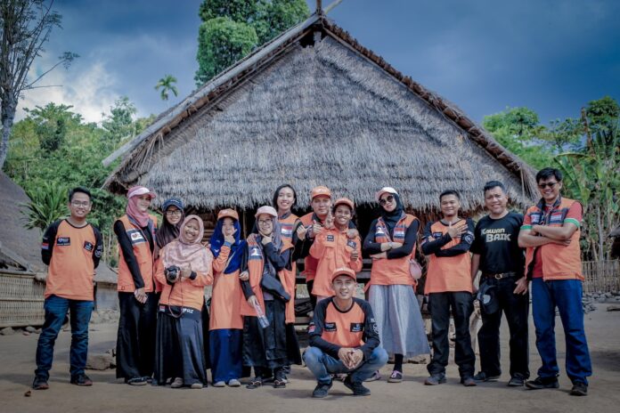 Photo by Su Nyoto group of people standing near brown wooden house