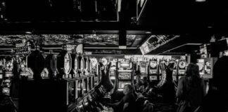 grayscale photo of man playing slot machine