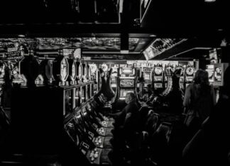 grayscale photo of man playing slot machine