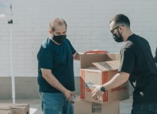Same-Day and Next-Day Delivery: The Key to Competing in the Modern E-commerce Landscape man in blue crew neck t-shirt standing beside brown cardboard boxes