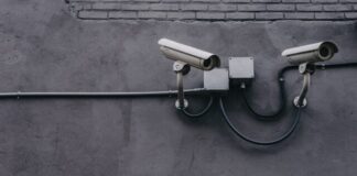 two bullet surveillance cameras attached on wall