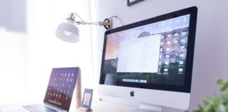 silver iMac near iPhone on brown wooden table