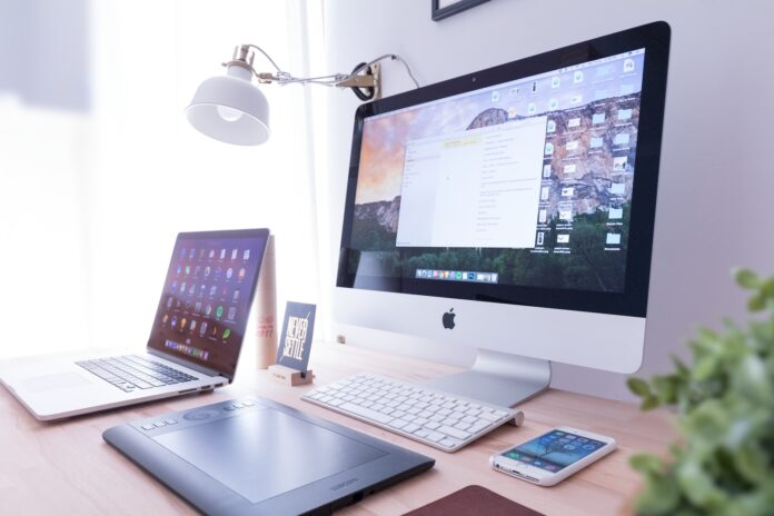 Photo by Domenico Loia silver iMac near iPhone on brown wooden table