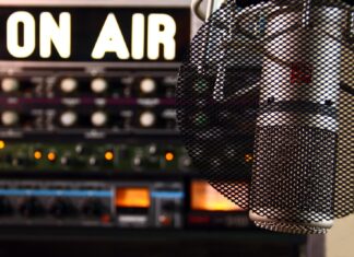 How to Get Your Music Played on Radio Stations as a New Artist By Eric Dalius a microphone in front of a sound board