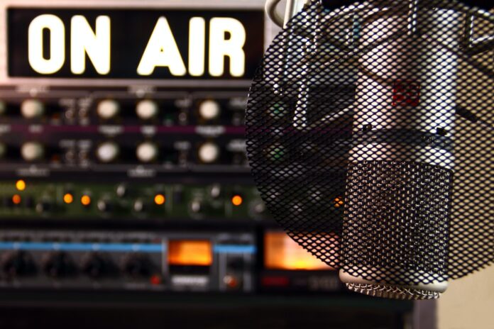 Photo by Fringer Cat a microphone in front of a sound board