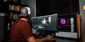 man in red t-shirt sitting in front of computer