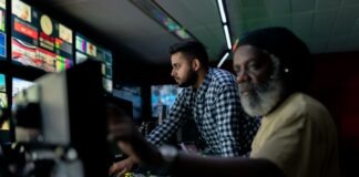 man in blue and white checkered button up shirt sitting beside man in yellow shirt