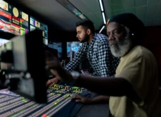 man in blue and white checkered button up shirt sitting beside man in yellow shirt