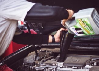 Top 5 Benefits of Regular Car Maintenance man refilling motor oil on car engine bay