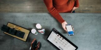 person holding smartphone beside tablet computer